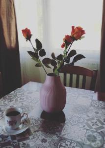 a vase with flowers sitting on a table with a cup of coffee at Zarakas home in Monemvasia