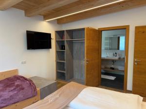 a bedroom with a bed and a flat screen tv at Appartements Danijela in Fügenberg