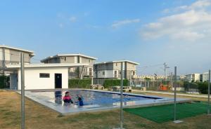 two children playing in a swimming pool in a house at Tanza Cavite Staycation Condo Loft in Tanza