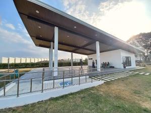 a large white building with a wooden roof at Tanza Cavite Staycation Condo Loft in Tanza