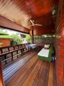 a wooden deck with a bed and a table on it at Golden Teak Resort Baan Sapparot in Kamala Beach