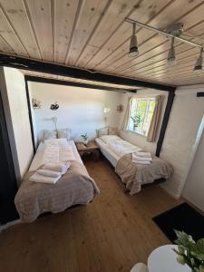 two beds in a room with wooden floors at Conedue B&B in Væggerløse