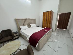 a bedroom with a bed and a table and a chair at Mangalm Farm & Resort in Greater Noida