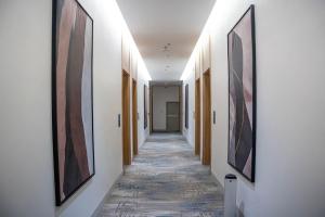 a corridor of a hallway with paintings on the walls at ارجان بارك طويق 3 in Riyadh