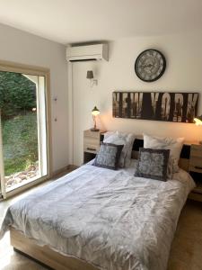 a bedroom with a large bed with a clock on the wall at Luxueuse villa piscine et jacuzzi in Saint Paul de Vence +41 photos