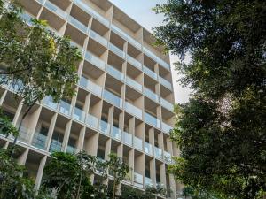 an office building with trees in front of it at Nomu Mexico City by Lumina in Mexico City +64 photos