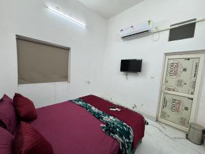 a bedroom with a bed and a tv on the wall at Mangalm Farm & Resort in Greater Noida