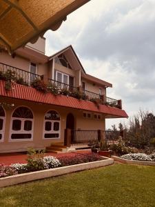 a house with a red roof and a yard at Rosewood 1 - 3BHK in Ooty
