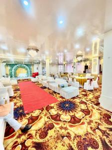a large room with white chairs and a red carpet at Shree Krishna Palace Hotel - Couple Friendly in Lucknow