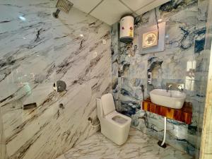 a marble bathroom with a toilet and a sink at Shree Krishna Palace Hotel - Couple Friendly in Lucknow +22 photos