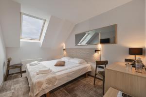 ein Schlafzimmer mit Bett, Schreibtisch und Fernseher in der Unterkunft Ivolita Vilnius in Vilnius