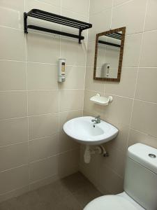 a bathroom with a sink and a toilet and a mirror at Lynn Homestay Alor Setar in Alor Setar +46 photos