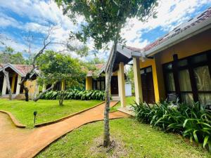 a house with a tree in front of it at Hotel Kamrel Sigiriya in Sigiriya