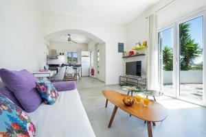 a living room with a white couch and a table at Villa Memories in Palaiochora