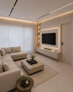 a living room with a couch and a tv at Al Badr Villas Resort in Sawdāʼ