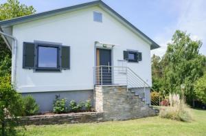 a white house with a staircase and windows at Haus am Waldrand in Göttschach +8 photos