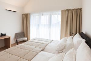 A bed or beds in a room at MÖRWALD Relais & Châteaux Hotel am Wagram