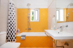 a bathroom with a sink and a tub and a toilet at Villa Memories in Palaiochora +44 photos