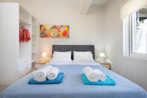 a bedroom with a blue bed with towels on it at Villa Memories in Palaiochora