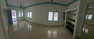 an empty room with a hallway with windows at Kattil Chennai in Chennai
