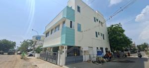 a white and blue building on the side of a street at Kattil Chennai in Chennai
