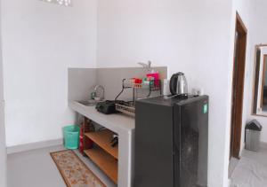 a kitchen with a black refrigerator in a room at Anorawi surf accommodation in Maluk