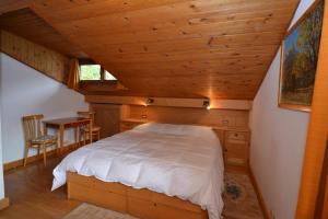 a bedroom with a bed and a table in a room at Attico Castello in Cortina dʼAmpezzo