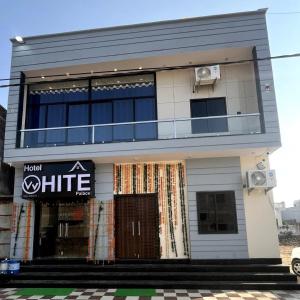 a white building with a sign on it at Hotel White Palace in Nāwa +2 photos