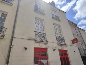 a white building with red doors and windows at cœur du Bouffay in Nantes +3 photos