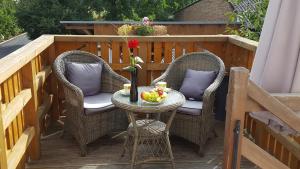 a patio table with two chairs and a table with fruit on it at Ferienwohnungen Villa Waldblick in Zempin