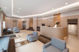 eine Lobby mit blauen Stühlen und einem Empfangstresen in der Unterkunft Ivolita Vilnius in Vilnius