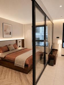 a bedroom with a bed and a glass wall at AMA Residences in Buon Ma Thuot