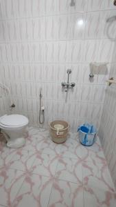 a bathroom with a toilet and a sink at Nirmali Homestay in Guwahati