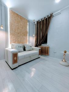 a living room with a white couch and a window at Taraz in Taraz