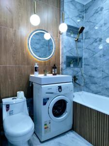 a bathroom with a washing machine and a toilet at Taraz in Taraz