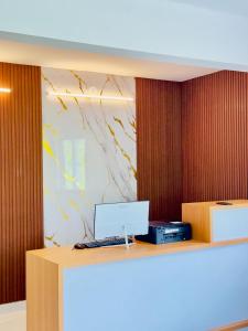 a desk with a laptop computer on top of it at Hotel Livora in Alwaye