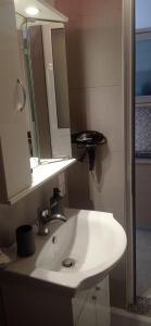 a bathroom with a white sink and a mirror at Sofia Comfort Apartment in Nivicë +33 photos