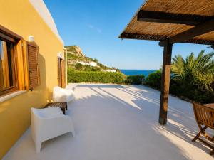 a patio with white chairs and a view of the ocean at Maridea - Vairone in Ponza +10 photos