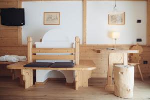 a room with a bed and a table and a desk at Pineta Nature Resort - Wellness & SPA in Coredo