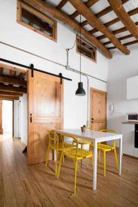 a dining room with a table and yellow chairs at Ca l'Espavil in Cardedeu