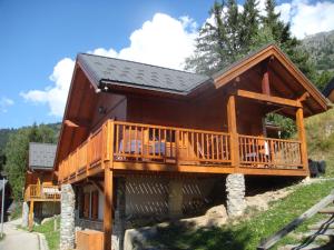 une grande cabane en rondins avec une grande terrasse dans l'établissement Chalet Clementine, à Oz