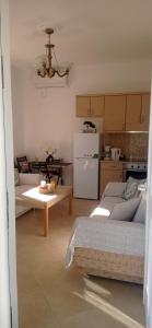 a kitchen with two couches and a table in a room at Sofia Comfort Apartment in Nivicë