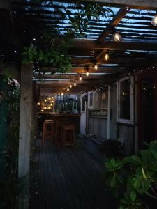 a wooden deck with a bar with lights on it at Le Bach - Rustic Central Raglan in Raglan