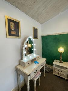 a room with a desk with a mirror and a greenboard at Le Bach - Rustic Central Raglan in Raglan