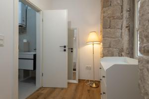 a white bathroom with a sink and a lamp at Dubrovnik Deluxe Rooms in Dubrovnik