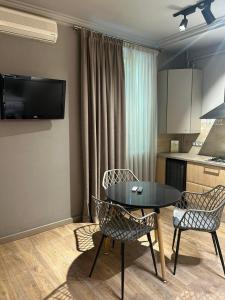 a living room with a table and chairs and a kitchen at Aparthotel in Chişinău +39 photos