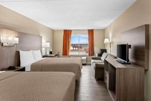 a hotel room with two beds and a flat screen tv at Econo Lodge Willowbrook in Burr Ridge