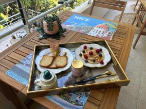 a table with a tray of breakfast food on it at Agréable chambre et salle de bain privée dans notre appartement partagé in Cannes +5 photos