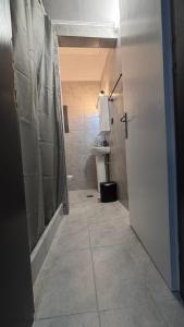 ein Badezimmer mit Dusche, Toilette und Tür in der Unterkunft The Waves Studio in Patras