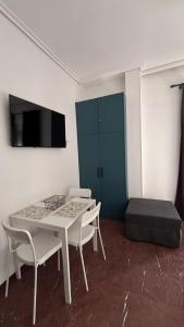 ein Zimmer mit Tisch, Stühlen und Fernseher in der Unterkunft The Waves Studio in Patras + 11 Fotos
